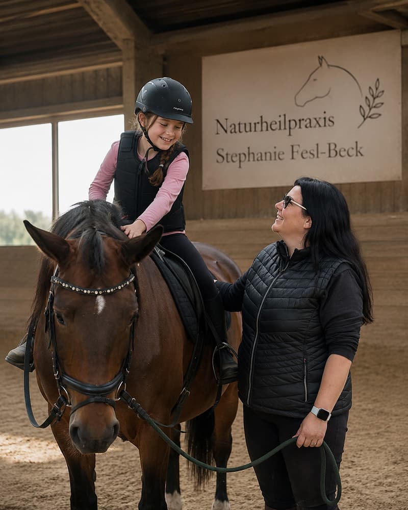 Mädchen auf Pferd während einer Reittherapie Heilpraktikerin Stephanie Fesl-Beck in München