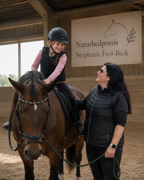Mädchen auf Pferd während einer Reittherapie Heilpraktikerin Stephanie Fesl-Beck in München